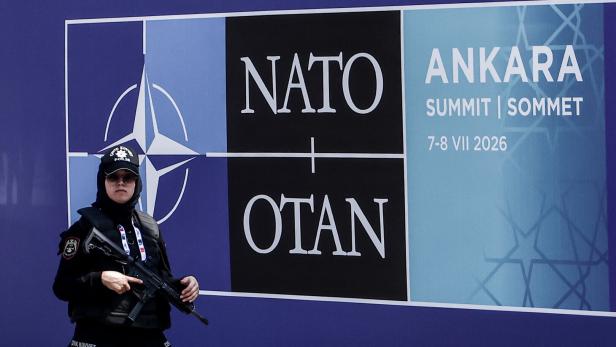 Bewaffnete Polizistin vor NATO/OTAN-Schild beim Ankara-Gipfel 2026.