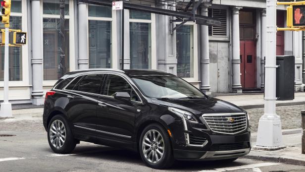 Ein schwarzer Cadillac XT5 steht an einer Strassenecke in der Stadt.