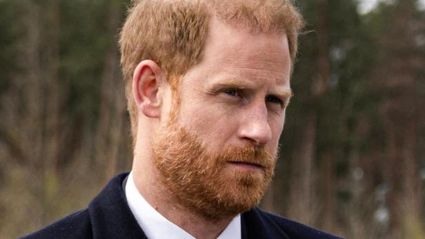 Prinz Harry in einem dunklen Anzug blickt ernst drein