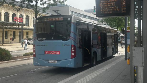 Bushaltestelle in St. Pölten mit wartendem Linienbus und digitaler Abfahrtsanzeige.
