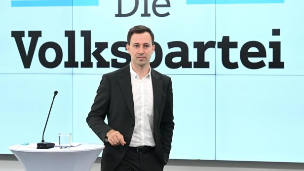 Mann im schwarzen Anzug vor der Aufschrift „Die Volkspartei“ in einem Studio.