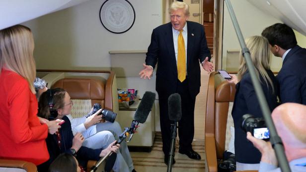 U.S. President Trump speaks to reporters mid-flight in the press cabin of the new Air Force One