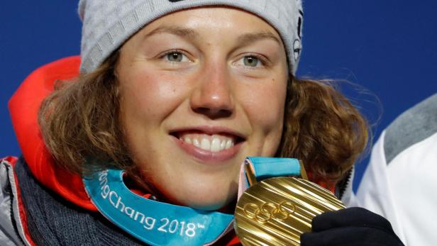 Laura Dahlmeier hält eine Goldmedaille der Olympischen Winterspiele 2018 in Pyeongchang vor ihr Gesicht.
