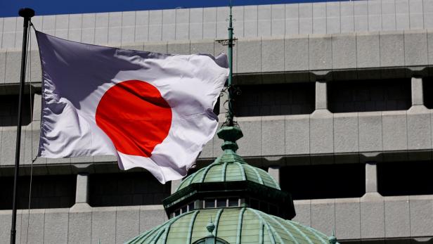 FILE PHOTO: Japanese national flag waves at the Bank of Japan building in Tokyo