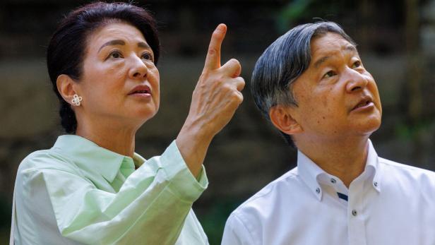 Kaiser Naruhito und Kaiserin Masako von Japan blicken gemeinsam nach oben, wobei die Kaiserin mit dem Finger in die Höhe zeigt.
