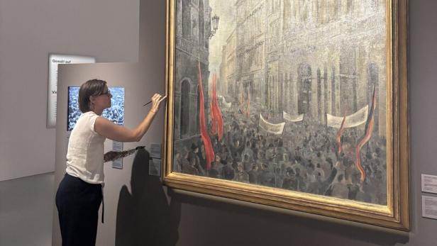 Eine Frau restauriert ein großes historisches Gemälde im Museum.