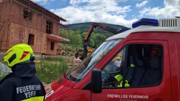 Feuerwehr und Rettungskräfte an einer Baustelle mit Einsatzfahrzeug und Kran.