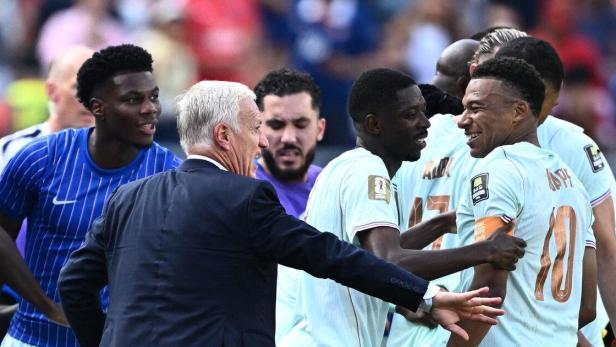 Frankreich in türkisen Trikots stehen auf dem Fußballfeld und schauen ihren Trainer an