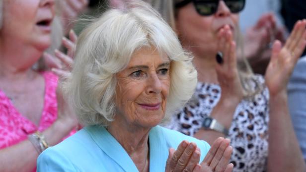 Königin Camilla applaudiert bei einer Veranstaltung, umgeben von weiteren Personen im Publikum.