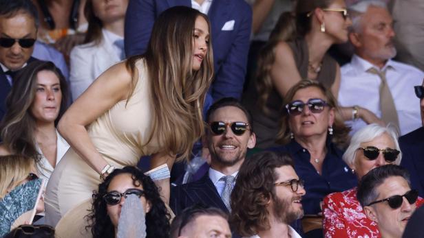 Jennifer Lopez und Tom Hiddleston sitzen auf der Zuschauertribüne bei einem Tennisturnier in Wimbledon.