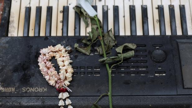 Verwelkte Rosen und eine Blumenkrone liegen auf einer alten Tastatur.
