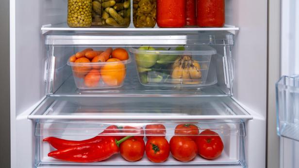 ein Kühlschrank voller Gläser, Gemüse und Obst, darunter Bananen und Tomaten