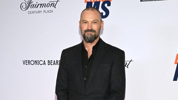 Brian Austin Green steht in einem schwarzen Anzug vor einer Sponsorenwand bei einer Veranstaltung im Fairmont Century Plaza.