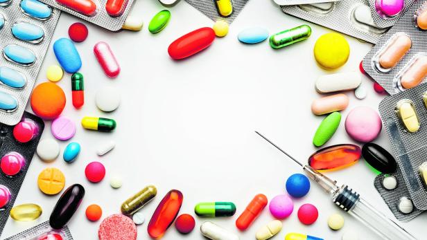 Large group of assorted capsules, pills and blisters making a frame on white background
