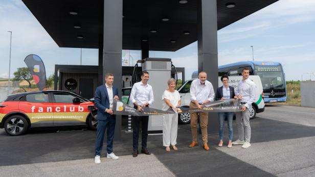 Sechs Personen durchschneiden feierlich ein Band zur Eröffnung einer E-Tankstelle der Burgenland Energie in Mattersburg.