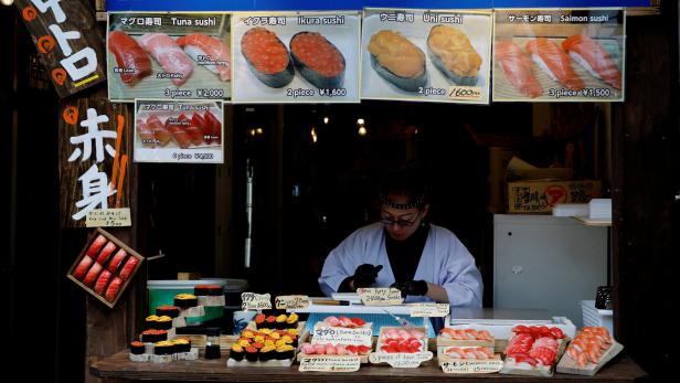 FILE PHOTO: A vendor works at a shop selling sushi rolls at Tsukiji Outer Market in Tokyo