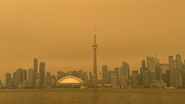 Downtown skyline is covered by wildfire smoke during a heat wave, as seen from the Toronto Islands on Lake Ontario