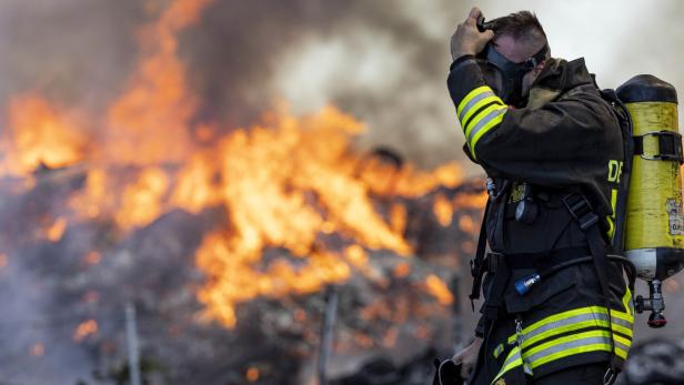 Feuerwehrmann mit Atemschutz vor großem Brand.