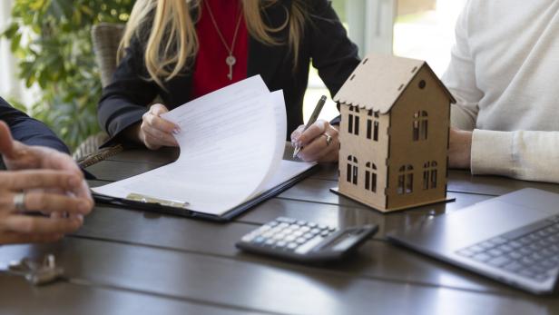 Estate agent and businessman signing sale agreement