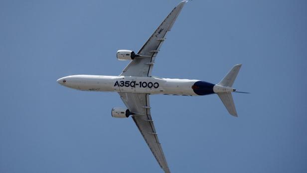 Ein Airbus A350-1000 fliegt mit ausgefahrenem Fahrwerk vor klarem blauen Himmel.