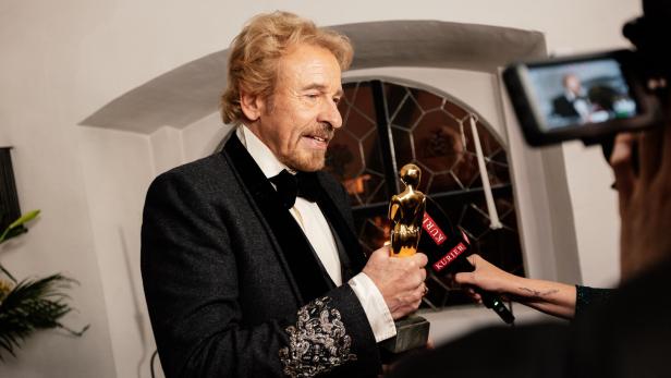 Thomas Gottschalk hält eine goldene Trophäe in die Mikrofone des Kurier.