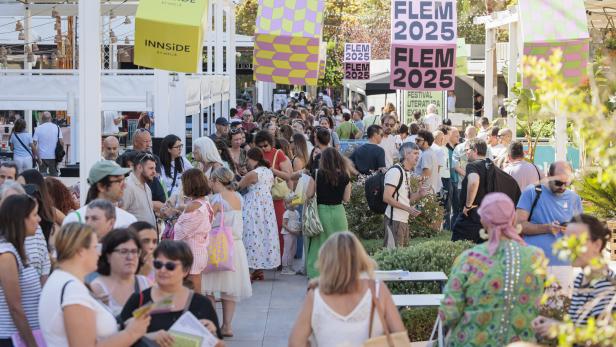 Menschenmenge auf einem literarischen Festival mit FLEM-2025-Bannern im Freien.