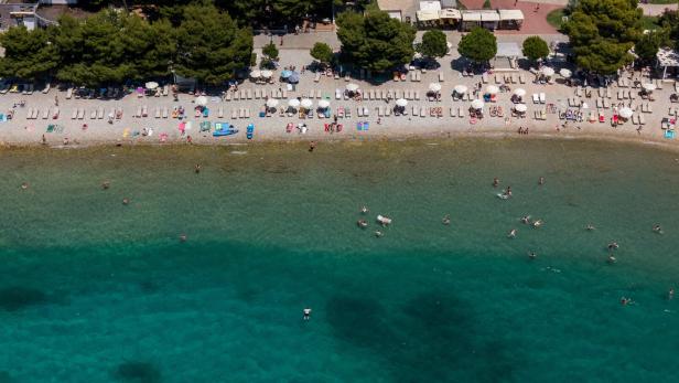 Drone view shows people swimming and sunbathing at the beach in Vodice