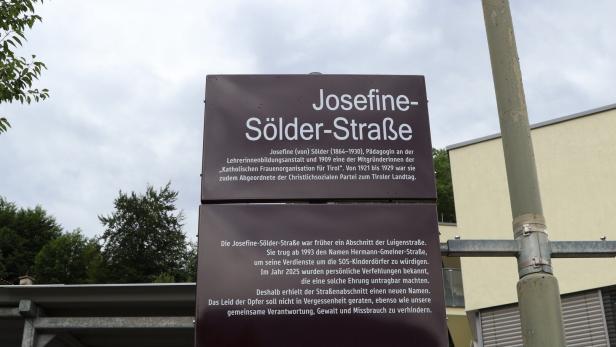 Straßenschild „Josefine-Sölder-Straße“ mit erklärendem Text auf braunem Schild.