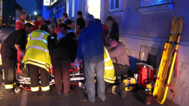Rettungskräfte versorgen eine verletzte Person auf einer Trage.