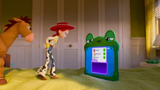 TOY STORY 5: Jessie und Bullseye betrachten einen grünen Frosch-Computer mit Freundesliste im Kinderzimmer.