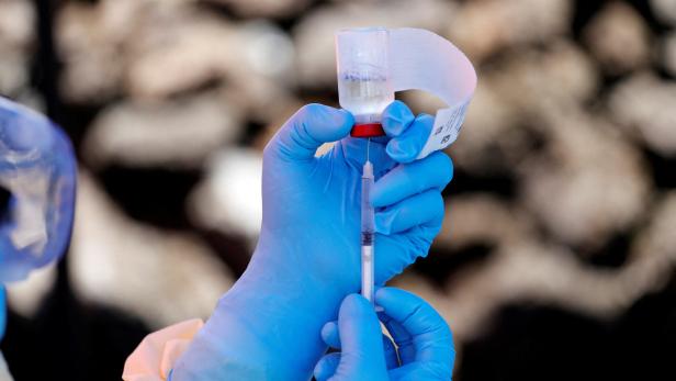 FILE PHOTO: A health worker fills a syringe with Ebola vaccine before injecting it to a patient, in Goma