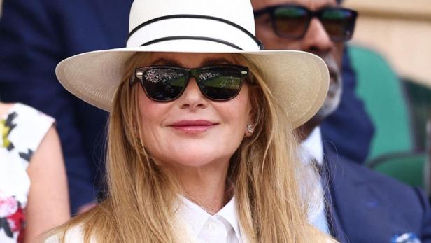 Nicole Kidman trägt einen weißen Hut und einen weißen Blazer, während sie auf der Tribüne in Wimbledon sitzt.