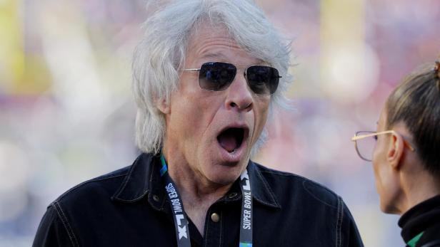 Jon Bon Jovi mit Sonnenbrille und offenem Mund bei einem Gespräch während des Super Bowl LVIII.