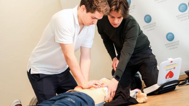 Das Bild zeigt zwei Medizinstudenten der Med Uni Innsbruck bei der Reanimation einer weiblichen Simulationspuppe.