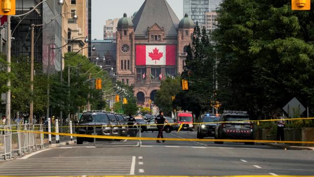 Police tape stretches across University Avenue as Toronto police work on the scene of a shooting at the U.S. Consulate in Toronto