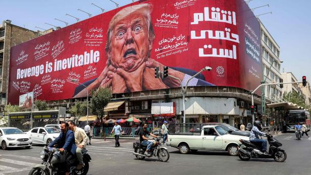 Autofahrer passieren in der Teheraner Innenstadt ein großes Plakat mit Drohbotschaft gegen US-Präsident Donald Trump.