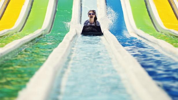 Three kids having fun sliding in a waterpark