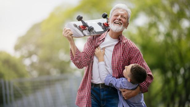 Grandfather and grandson having fun, skateboarding