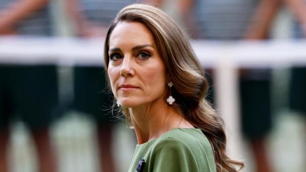 Catherine, Prinzessin von Wales, trägt ein olivgrünes Kleid und blickt ernst zur Seite.