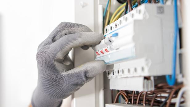 Electrician Testing Fuses In the Electric Box