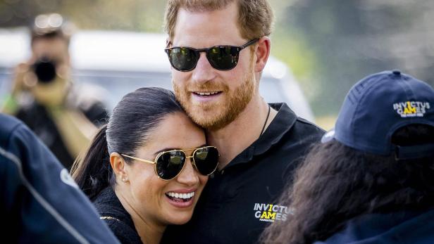 Prinz Harry und Meghan Markle umarmen sich lächelnd bei einer Veranstaltung der Invictus Games.