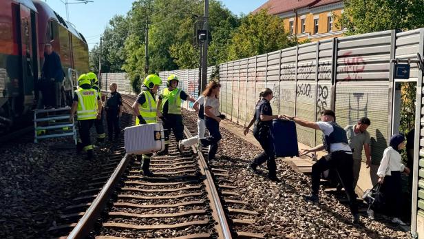 Menschen gehen über Bahngleise