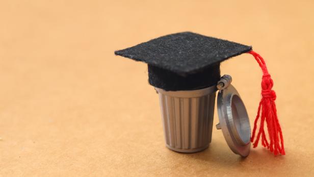 Devaluation of Academics: Mortarboard Discarded in Garbage Bin