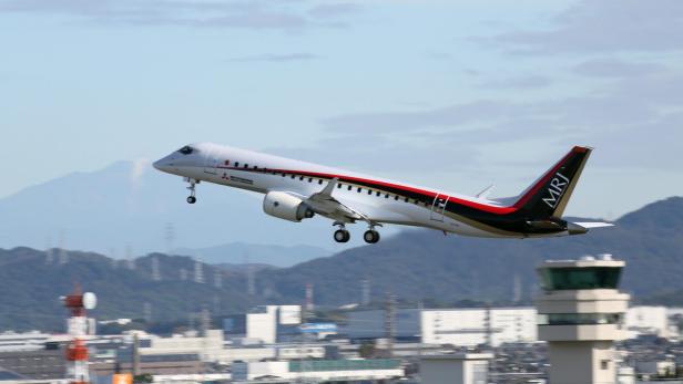Ein Mitsubishi SpaceJet hebt von einem Flughafen ab.