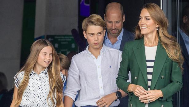 Prinz William und Prinzessin Catherine gehen mit ihren Kindern Prinz George und Prinzessin Charlotte aus einem Gebäude.