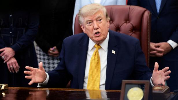 FILE PHOTO: U.S. President Donald Trump signs an executive order in the Oval Office at the White House in Washington