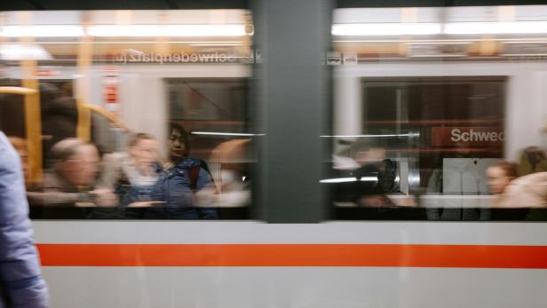 Eine Gruppe von Menschen, die in einem U-Bahn-Zug der Wiener Linien fahren