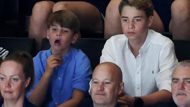 Prinz George und Prinz Louis sitzen auf einer Tribüne und schauen aufmerksam zu.