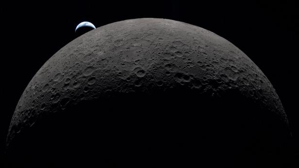 FILE PHOTO: A view of Earth, partially hidden by the Moon, photographed through the Orion spacecraft window