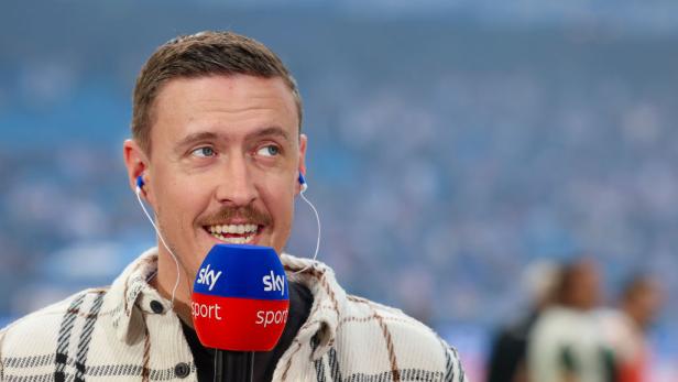 Max Kruse spricht bei Sky Sport mit einem Mikrofon und blickt lächelnd zur Seite.
